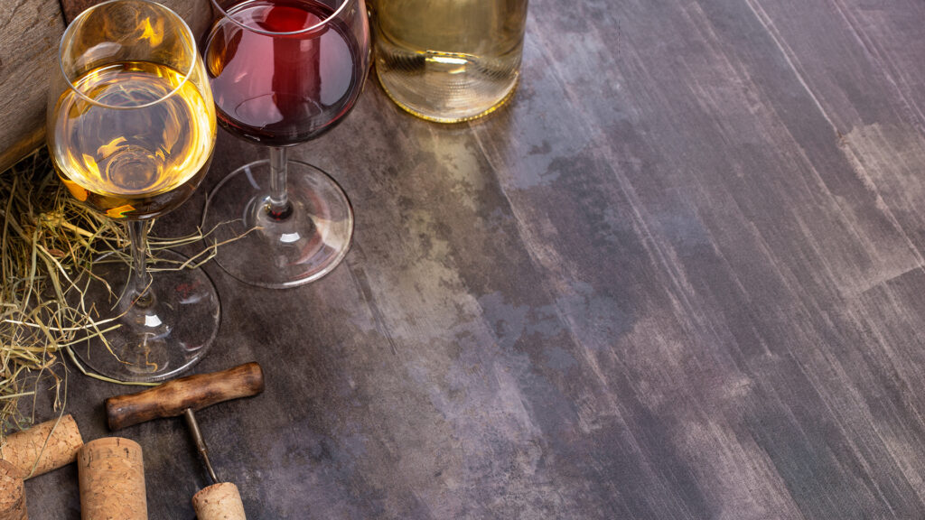 Weisswein- und Rotweingläser nebeneinander auf Holztisch im aagne weingut