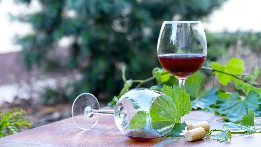 Glas Rotwein auf Tisch im Weingut Cave de La Côte