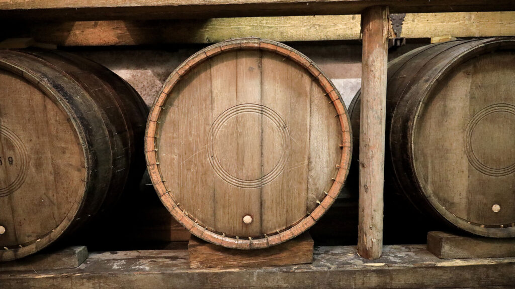 Holzfässer im Weinkeller von Château d'Auvernier während Weinlagerung