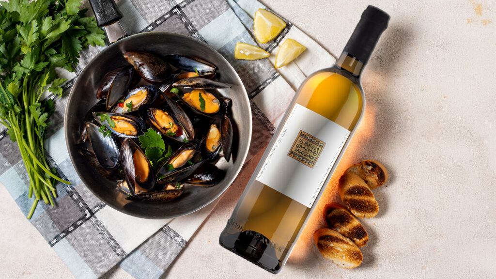 Eine Flasche Sauvignon Blanc von der Domain Hutis neben Teller mit Meeresfrüchten als Foodpairing