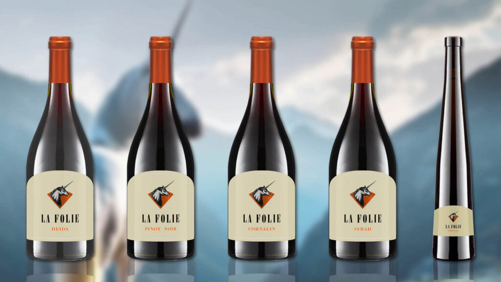 Fünf Weinflaschen der Marke La Folie mit unterschiedlichen Etiketten von der Cave de l'Hospice de Salquenen