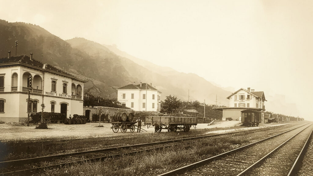 Historisches Foto zeigt ein Weingut und Bahngleise in einer ländlichen Landschaft, inspiriert von Matasci Vini seit 1921.