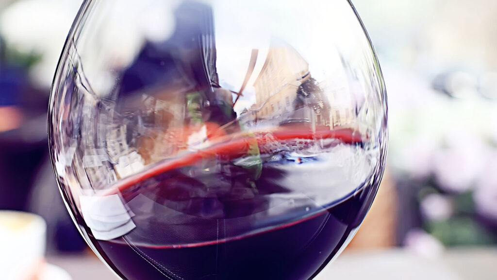 Nahaufnahme der Oberfläche von Rotwein in einem grossen Glas.