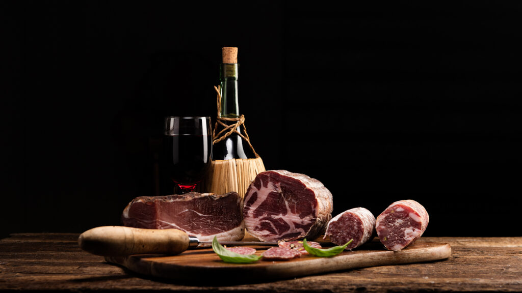 Wine region Italy Red wine next to meat dishes on a wooden board